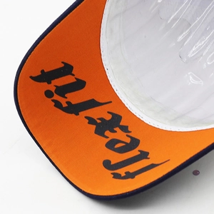 Detail of baseball cap brim showing 3D gothic lettering and internal structure