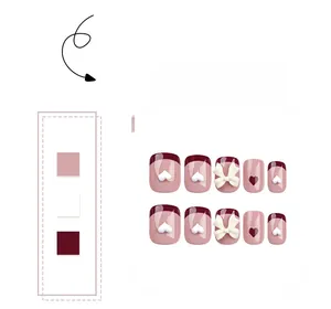 Detail view of pink and wine red press-on nails with 3D white bows and heart accents