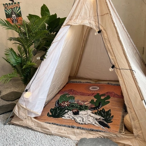 Bohemian picnic blanket with fringe and cactus pattern inside a cozy cream teepee tent