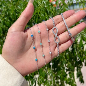 Detail showing four S925 silver Mobius bracelets with opal stones and zircon infinity charms