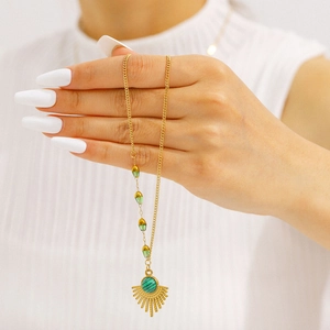 Vintage stainless steel necklace with fan-shaped emerald stone worn on a golden chain