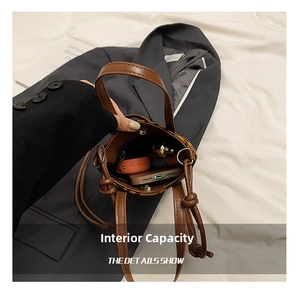 Detail showing internal capacity of the brown leopard print crossbody mini bucket bag