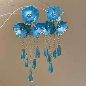 Detailansicht der blauen Kristallblumen-Ohrringe mit eleganten langen Goldquastenketten
