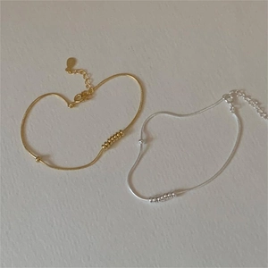 Detail of silver and gold snake chain bracelets with beads and adjustable lobster clasp