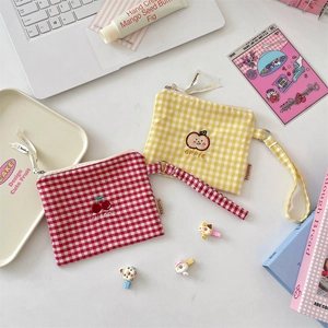 Detail of cute checkered coin purses with cherry and apple embroidery and wrist straps