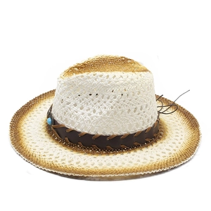 Dettaglio della trama in paglia intrecciata e perla turchese sul cappello cowboy