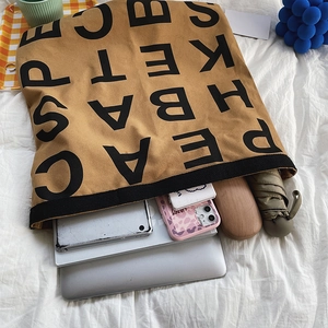 Brown canvas tote bag showing spacious interior with laptop and everyday essentials