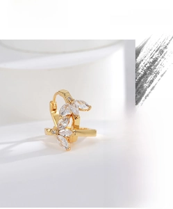 Macro detail of gold plated earrings featuring sparkling marquise-cut zircon leaf patterns