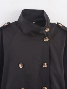 Detail of black double-breasted trench coat neckline with buckle and shoulder silhouette