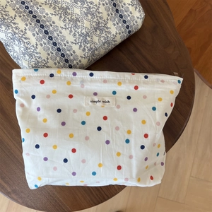 Close-up of white fabric pouch with colorful polka dots and simple wish cloth label