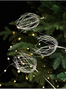 Détail d'ornements sphériques blancs pailletés sur tiges pour décoration de Noël