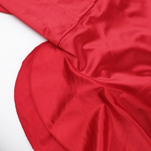 Gros plan détaillé du tissu en satin rouge montrant les coutures et la texture lisse