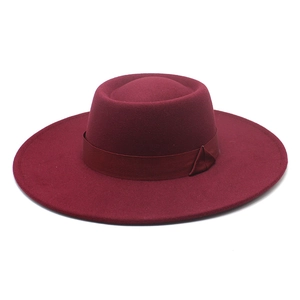Detail of burgundy wool fedora hat featuring flat top crown and grosgrain ribbon band