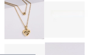 Close-up of double-layered gold necklace with minimalist beads and hollow heart pendant