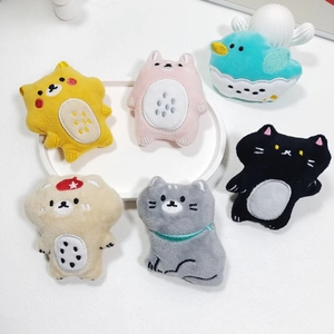 Detail of plush cartoon bear and cat charms with intricate embroidery and soft fabric