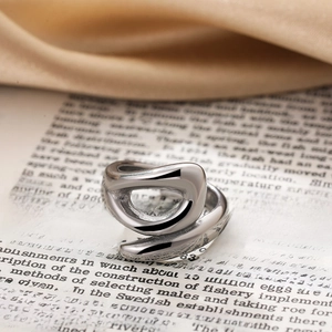 Macro shot of silver knot ring with twisted geometric design on vintage book pages