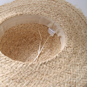 Internal view of raffia sun hat with 100% paper fiber weave and windproof straps