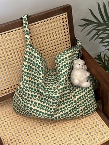 Floral canvas tote bag with green tulip print and plush lamb charm on a vintage chair