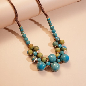 Gros plan de perles en céramique turquoise sur un collier tissé multicouche au style bohème