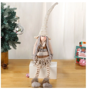 Detail of Christmas elf doll with beige knitted long hat and gray braided hair decor