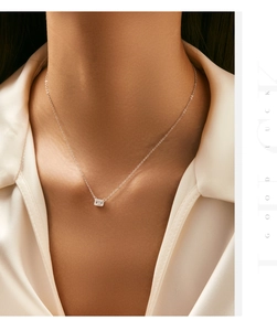 Close-up of S925 sterling silver geometric pendant necklace on model with silk shirt