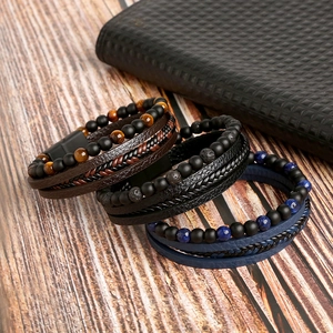 Detail of layered leather bracelets with tiger eye stones on rustic wood background