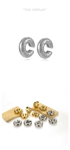 Detail of gold and silver hammered metal ear cuffs on beige stone for a textured look