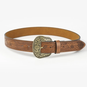 Detail of vintage brown leather belt with embossed floral patterns and bronze buckle