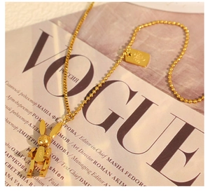 Detail of golden mechanical rabbit necklace with LUCKY engraving on Vogue magazine