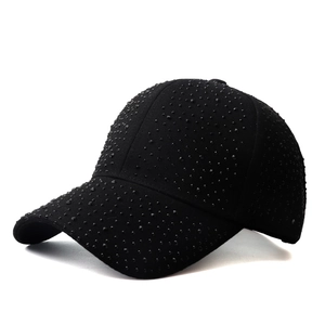 Detailed close-up of sparkling black rhinestones on a cotton baseball cap surface