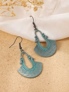 Close-up of bohemian verdigris alloy earrings with intricate filigree and drop shape