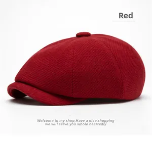 Detail of red wool blend newsboy cap showing twill texture and decorative top button