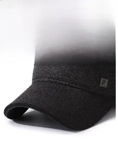 Dettaglio della visiera rigida e del logo in metallo su un cappello di lana antracite