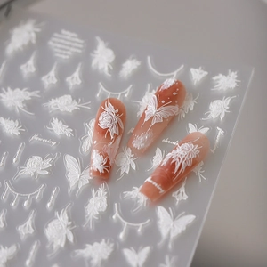 5D embossed nail stickers featuring white floral, butterfly designs on pink press-on nails