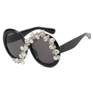 Oversized black round sunglasses for women featuring asymmetric S-shaped rhinestone decor