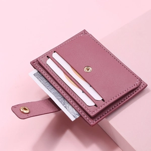 Macro detail of plum purple leather card holder with secure metal snap and fine stitching