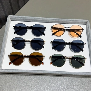 Retro round metal sunglasses for women in six stylish colors on a display tray