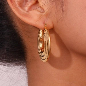 Close-up of layered gold hoop earrings with ribbed texture on model for a trendy look