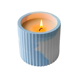 Blue and white marble texture ceramic candle jar with vertical ribs and burning flame