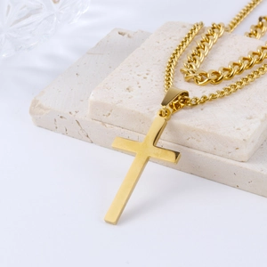 Detailed view of men's gold cross pendant with double layered cuban and twist chains