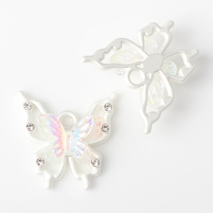 Detail of pearl white resin butterfly charm with rhinestone inlay for DIY jewelry