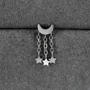 Macro detail of silver moon and star fringe tassel pendant on a grey velvet display