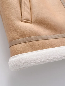 Close-up of camel faux leather and white shearling hem detail on a winter vest