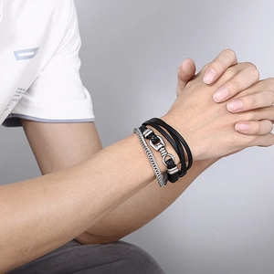 Detailed close-up of men's multi-layer braided leather and silver metal chain bracelet