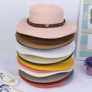 Detail view of colorful wide brim straw hats with metal bull head badges and rivet bands