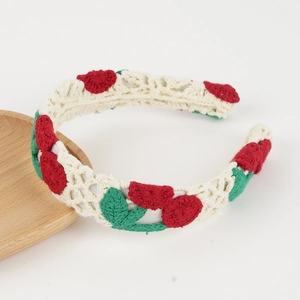 Detailansicht des handgestrickten Häkelstirnbands mit Kirschblüten auf cremefarbener Spitze