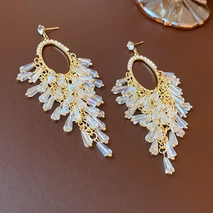 Close-up of golden tassel earrings with sparkling iridescent faceted crystal beads