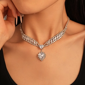Macro shot of silver heart pendant necklace with shimmering zircon stones on a model