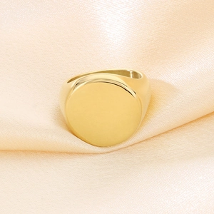Dettaglio di un anello a sigillo in acciaio placcato oro 18K su seta color champagne