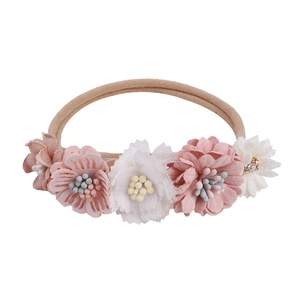 Detailed macro view of pink and white fabric flowers on baby nylon headband